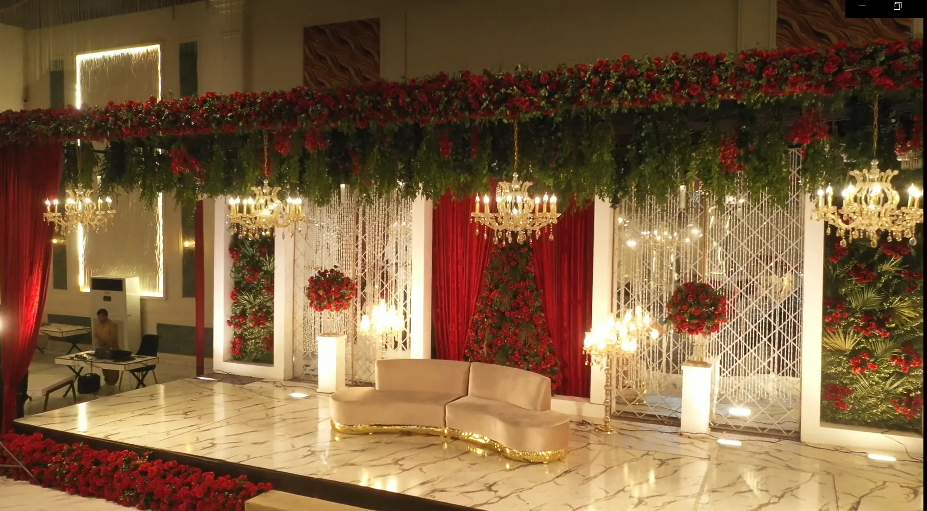 Luxury wedding stage with red roses and crystal chandeliers by Saudi Event Management